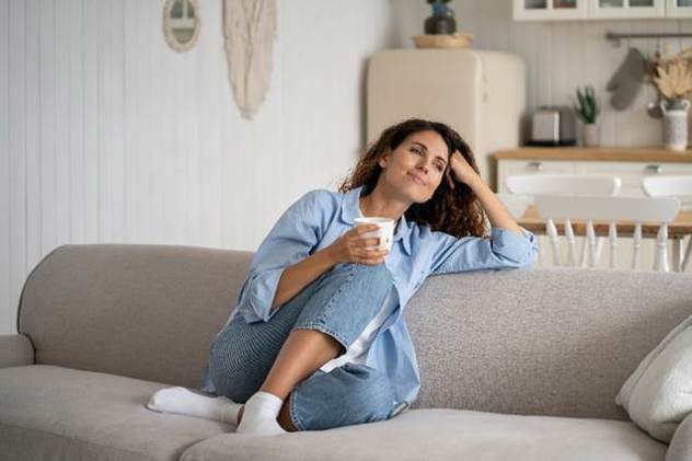 A person sitting on a couch holding a cup
AI-generated content may be incorrect.